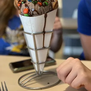 Bubble waffle ice cream cone with chocolate ice cream and mnm&apos;s.