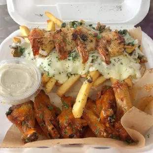 chicken wings and fries in a styrofoam container