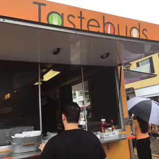 a man and a woman standing in front of a food truck