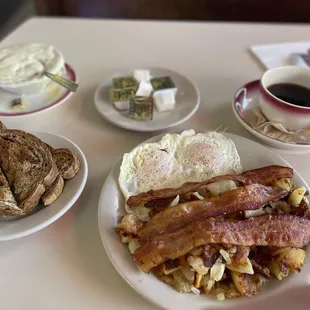 Over easy eggs, bacon, potatoes with onion, rye toast, chipped beef gravy, and coffee.