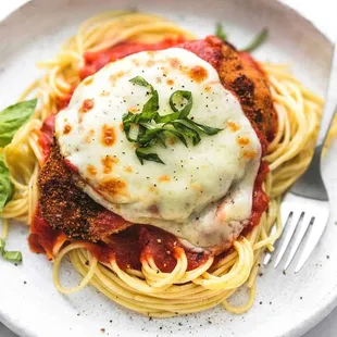 a plate of spaghetti with chicken parmesan