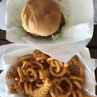 Single-patty burger and spicy curly fries