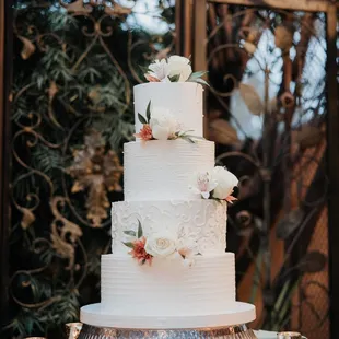 a white wedding cake with fresh flowers