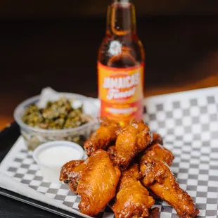 a plate of chicken wings and a bottle of beer