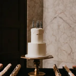 a three tiered cake and cupcakes