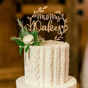 a white wedding cake with greenery