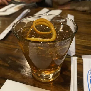 a drink in a glass with an orange twist