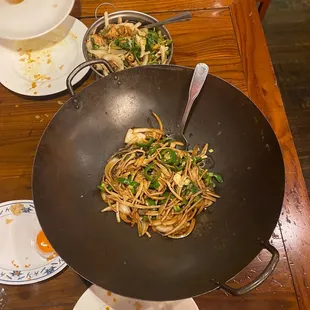 a wok with noodles and vegetables