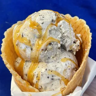 Caramel Cheesecake Cookie Moster in a fresh made waffle cone