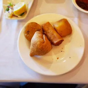 Half of the vegetarian sampler platter somosa, aloo tiki, paneer pakora and spring roll.