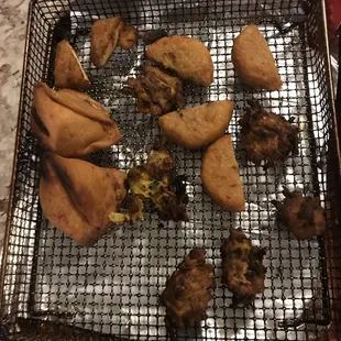 What I got. Seriously??! ONE Paneer pakora CUT IN HALF. TWO aloo tikki CUT IN HALF.  TWO samosas. This is false advertising.