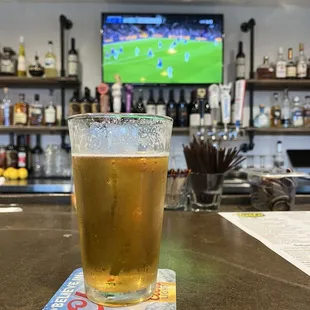 a glass of beer on a bar