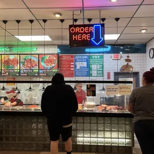 two people standing in front of a counter