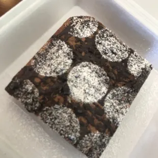 a square piece of cake with powdered sugar on top