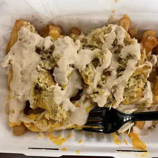 Crabby Cone - split crab cake on top of French fries, covered with sauce, and cheese on the bottom