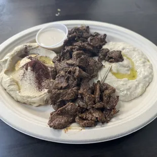 Beef Meat Shawarma Entree with Hummus and Mtable sides.