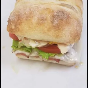 a sandwich with meat, cheese, tomato, and lettuce