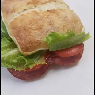 a sandwich with lettuce and tomatoes