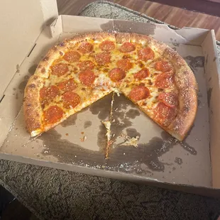 a half eaten pepperoni pizza in a box