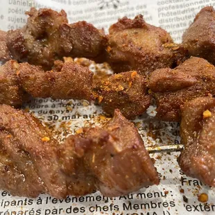 meat skewers on a newspaper