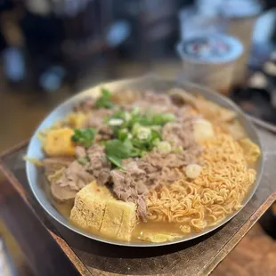 a plate of noodles and meat