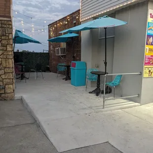 a patio with tables and umbrellas