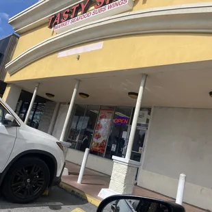 a car parked in front of a tasty shop