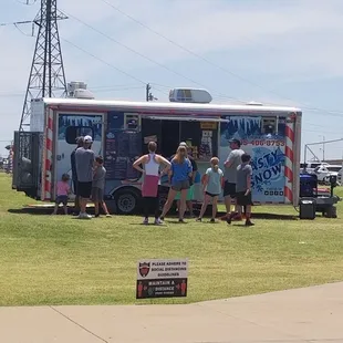 a group of people standing in front of a food truck