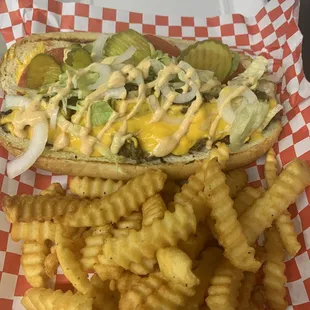 Cheesesteak Hogie with cheddar cheese sauce, lettuce tomato, onions, pickles, and French fries.