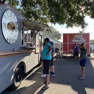 a group of people standing in front of a food truck