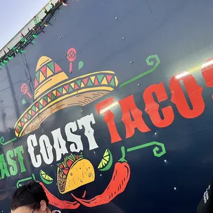 a woman standing in front of a taco truck