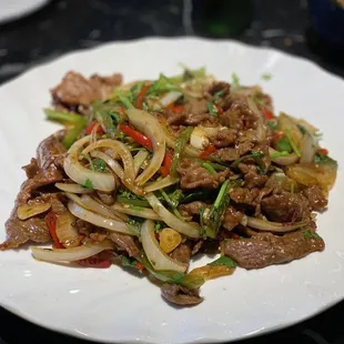 a plate of stir fried beef and vegetables