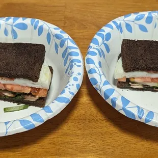 two sandwiches on paper plates