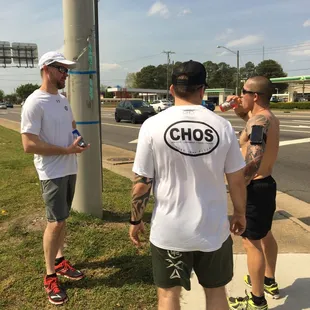 a group of men standing on a sidewalk