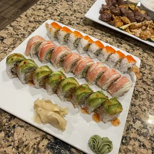 a plate of sushi and a platter of vegetables