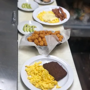 Scrapple and eggs with toast and a side of avocado  and tots