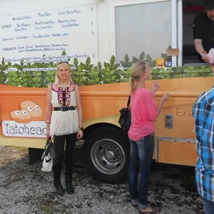 a woman standing in front of a food truck