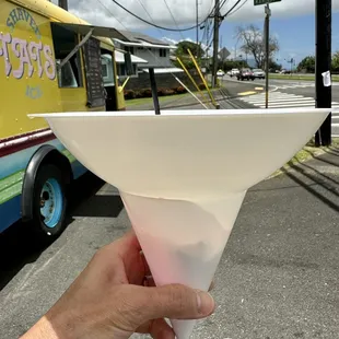 a hand holding a cone of ice cream