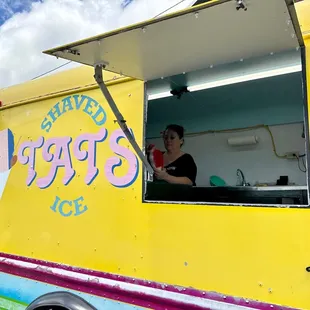 a woman in a yellow ice cream truck