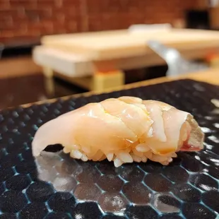 a sushi on a black plate