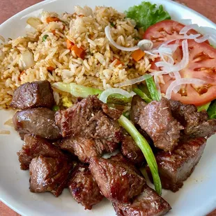 a plate of meat, rice and vegetables