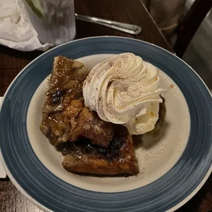Bread pudding with ice cream and homemade whipping cream topped with cinnamon this is the favorite dessert here by far