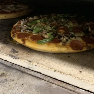 two pizzas cooking in an oven