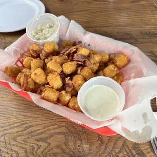 Tater tots with bacon, blue cheese crumbles, ranch dressing and melted cheese