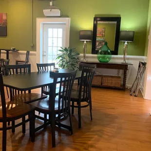 a dining room with green walls and wood floors
