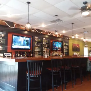 a bar with chairs and a television