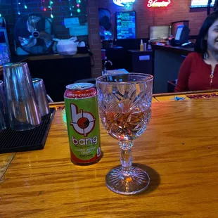 a woman sitting at a bar with a can of soda
