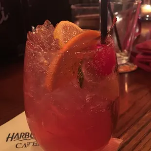 a pink drink with orange wedges