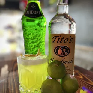 a bottle of tito's lemonade and limes