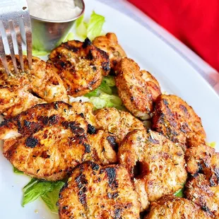 a plate of chicken skewers